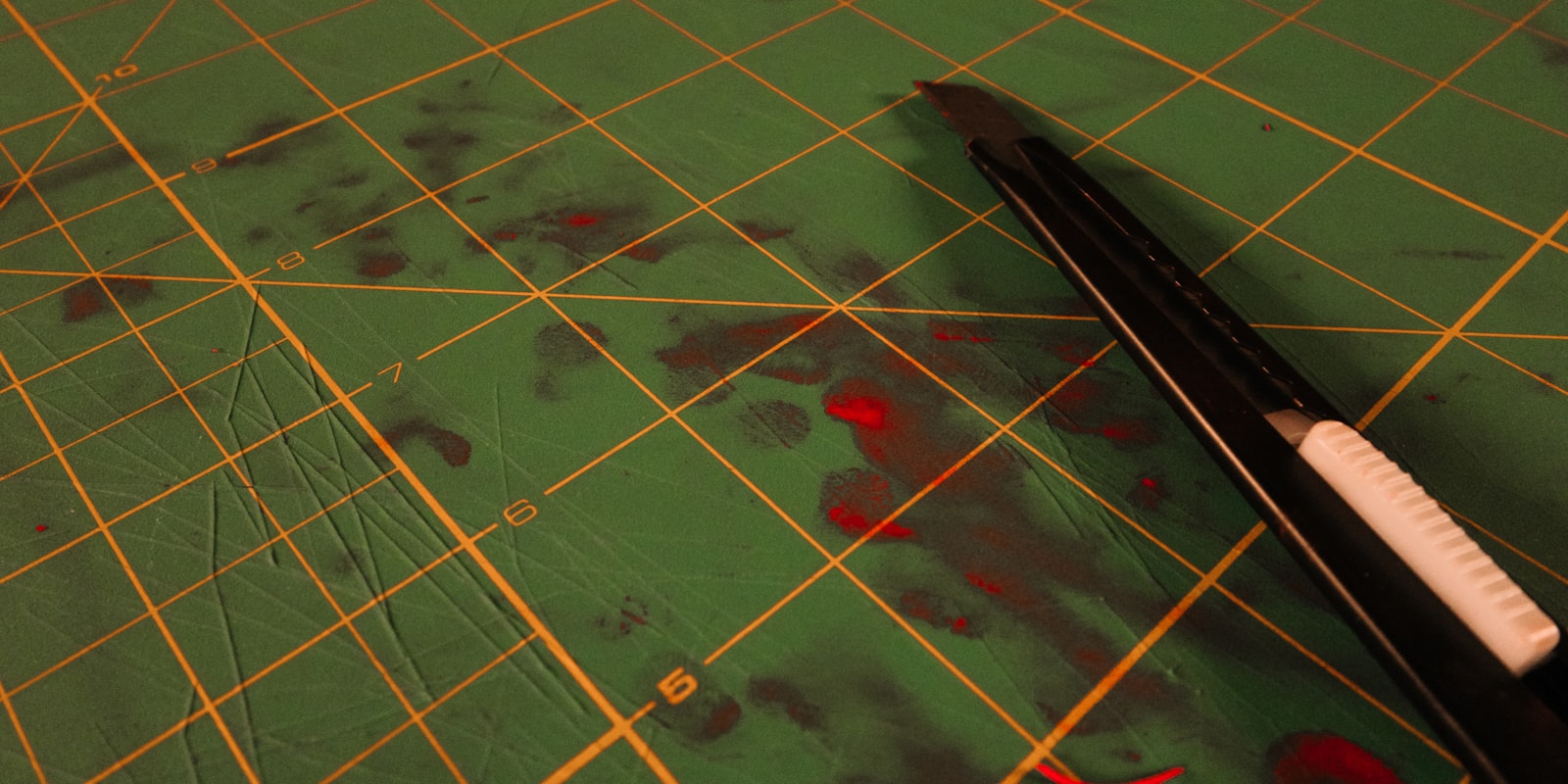 Cuttermesser auf einer abgenutzten grünen Schneidematte