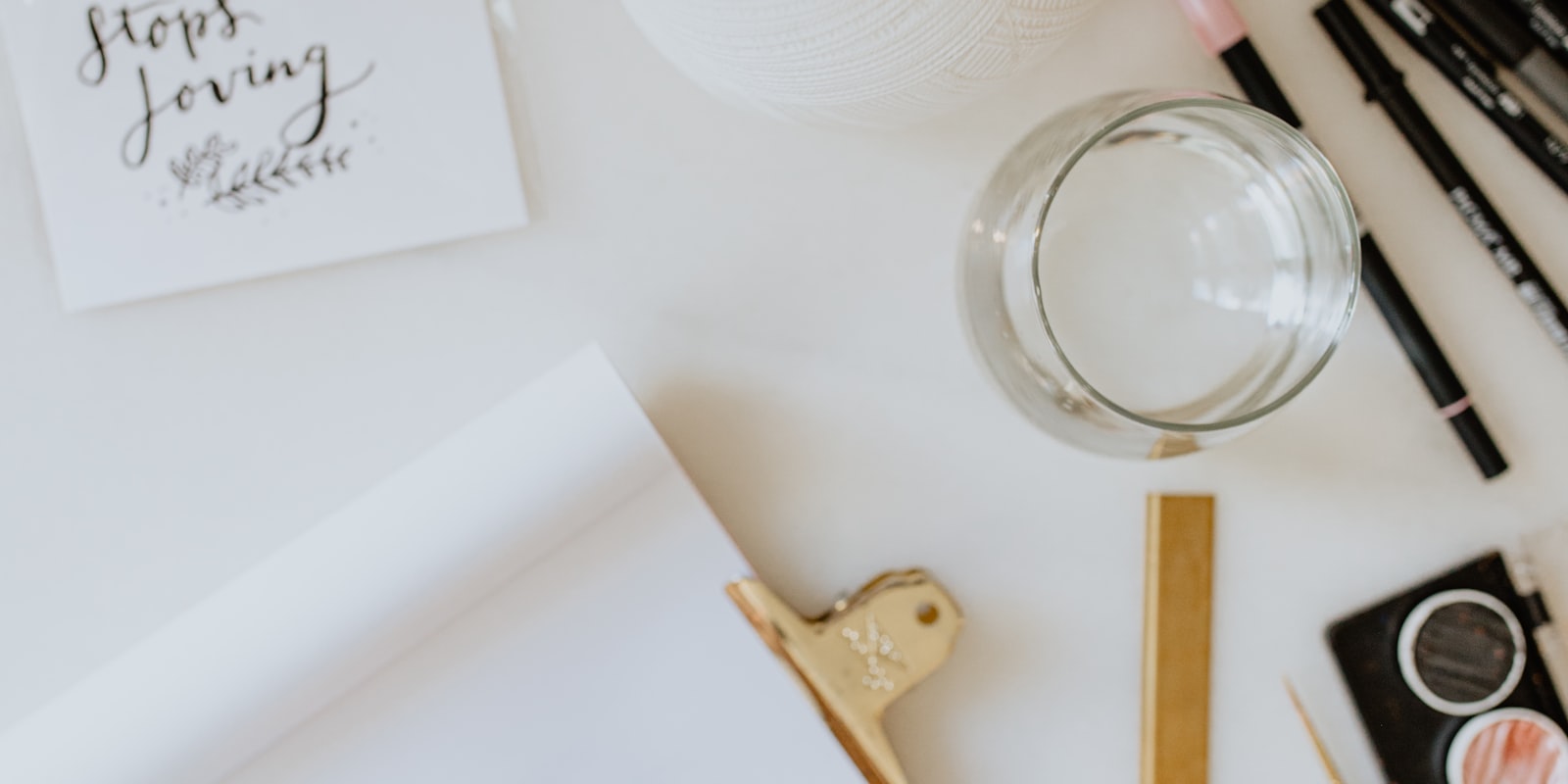 Handlettering-Arbeitsplatz mit Stiften und beschriebenem Papier