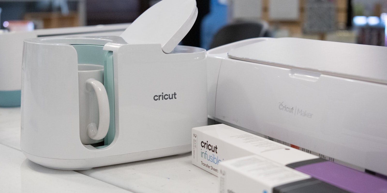 Cricut-Schneidemaschine und Becherpresse auf einem Arbeitstisch