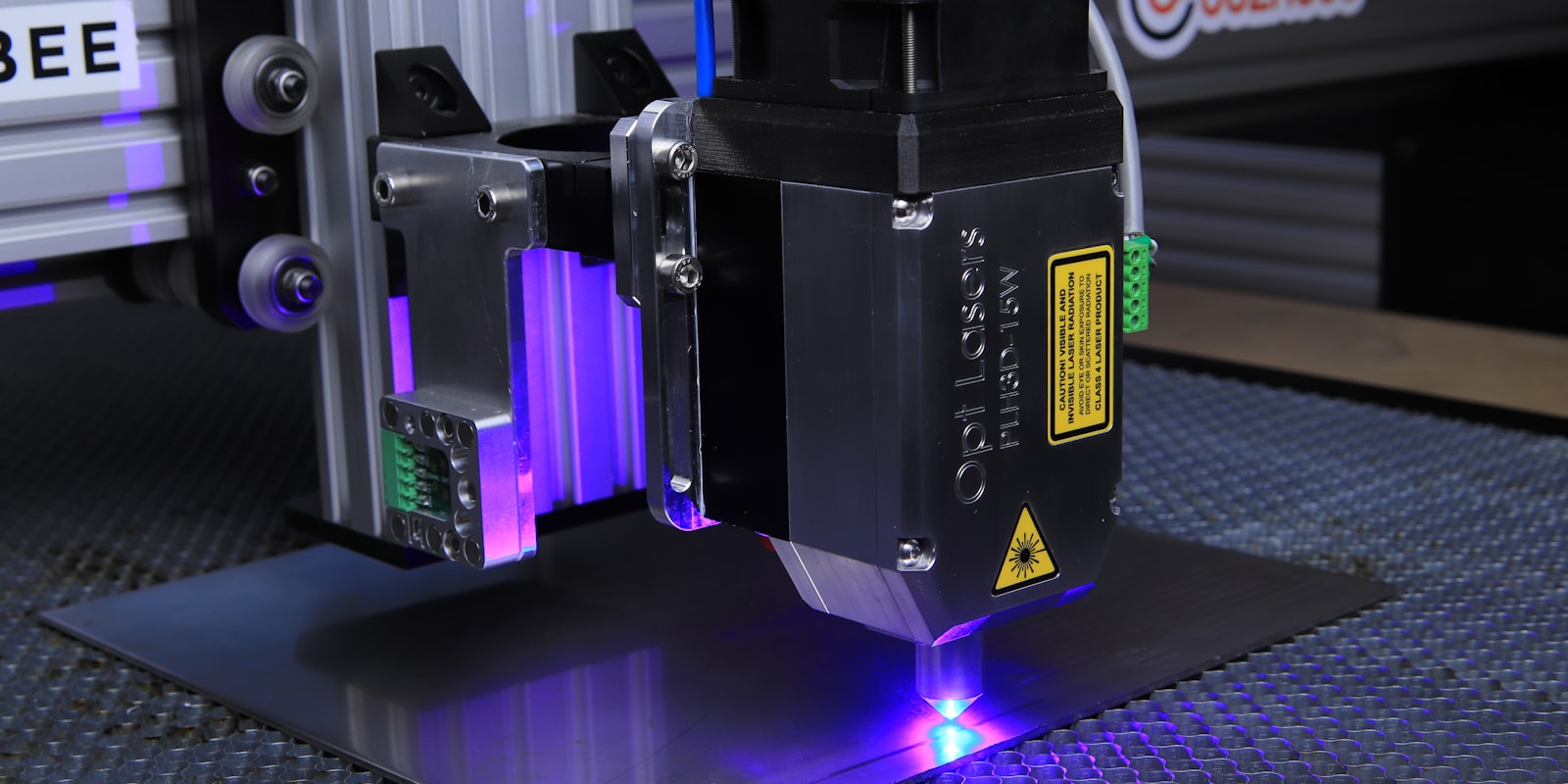 Ein Lasermodul graviert eine Platte, violettes Licht am Arbeitspunkt